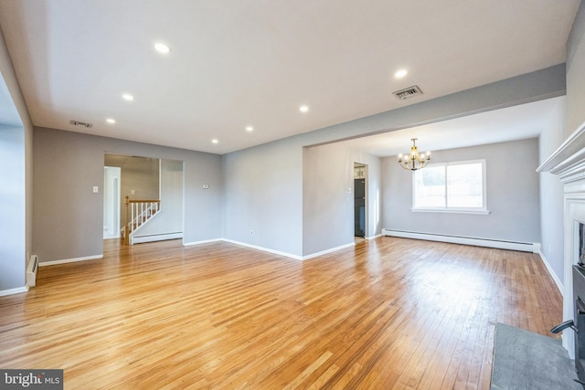 unfurnished living room featuring an inviting chandelier, light hardwood / wood-style flooring, and a baseboard radiator