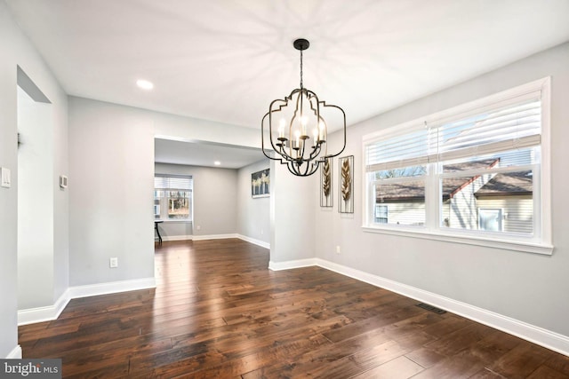 unfurnished dining area with a chandelier, dark hardwood / wood-style flooring, and plenty of natural light