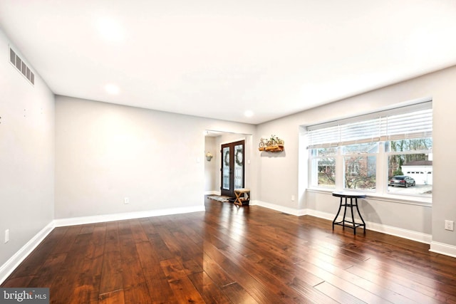 spare room featuring french doors and dark hardwood / wood-style floors