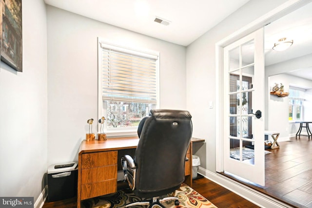 office space with dark hardwood / wood-style floors, a wealth of natural light, and french doors