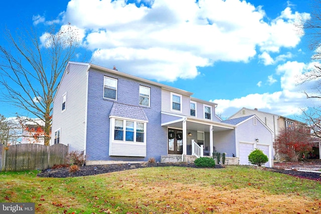 view of front of house featuring a porch, a garage, and a front yard