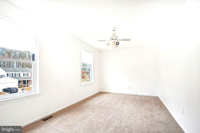 empty room with ceiling fan and carpet floors