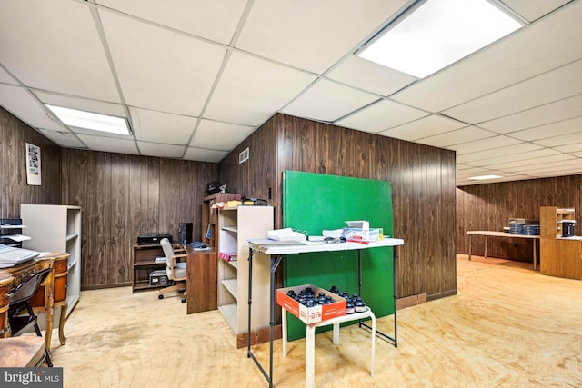 office area featuring a paneled ceiling and wood walls