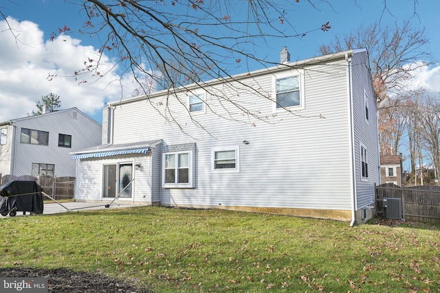 back of house with a lawn, central AC unit, and a patio area