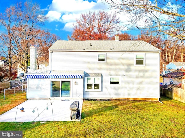 rear view of property featuring a patio and a lawn