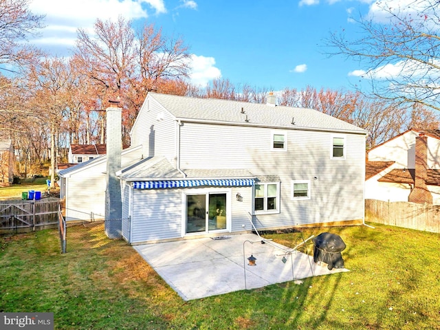 back of property with a lawn and a patio area