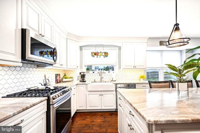 kitchen featuring white cabinets, hanging light fixtures, sink, dark hardwood / wood-style floors, and appliances with stainless steel finishes