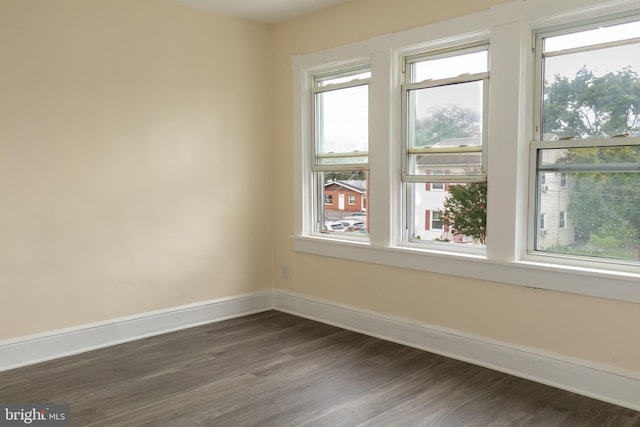 unfurnished room with dark hardwood / wood-style flooring