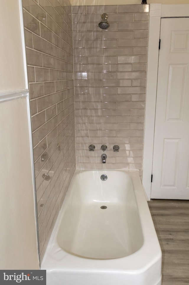 bathroom with tiled shower / bath combo and wood-type flooring