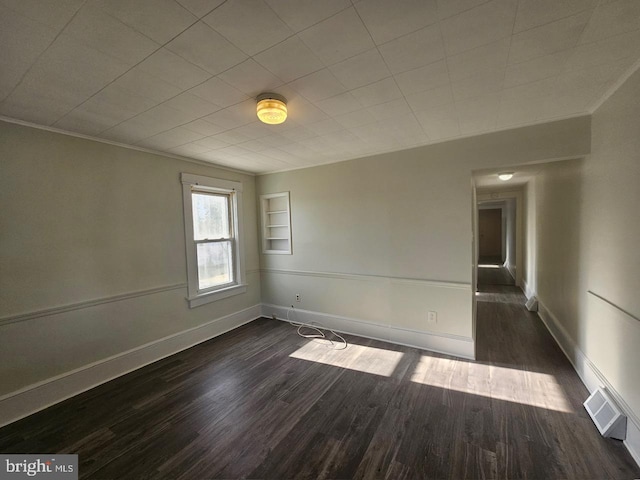 unfurnished room featuring crown molding and dark hardwood / wood-style floors