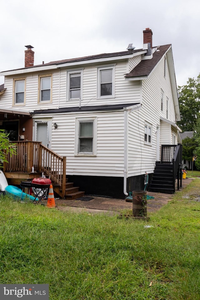 rear view of house featuring a yard