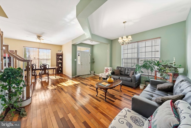 living room featuring light hardwood / wood-style flooring and ceiling fan with notable chandelier