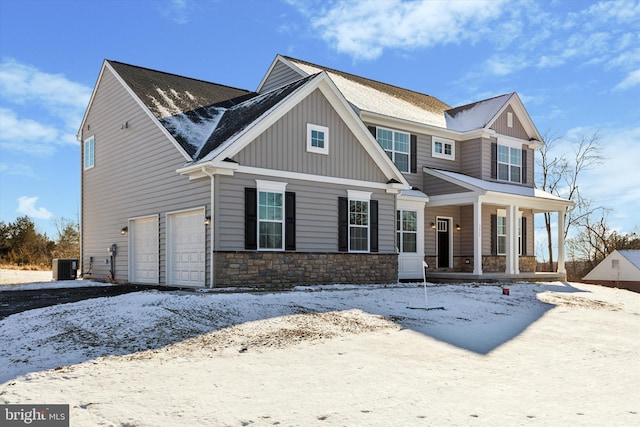 view of front of home with cooling unit, covered porch, and a garage