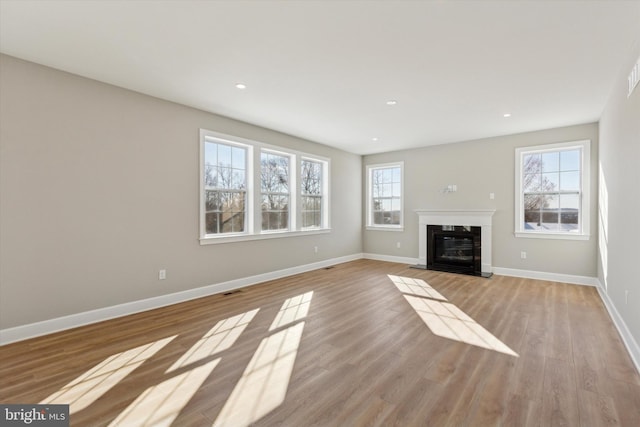 unfurnished living room with light hardwood / wood-style floors and a wealth of natural light