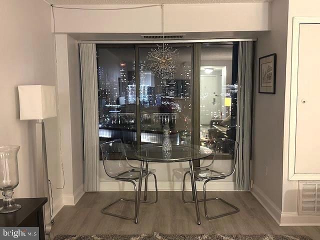 interior space with baseboards, visible vents, and wood finished floors