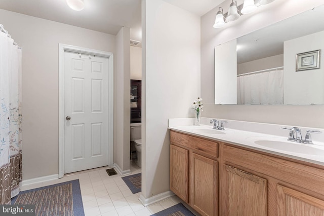 bathroom featuring tile patterned floors, vanity, and toilet