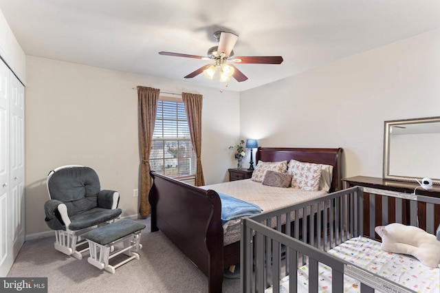 carpeted bedroom featuring ceiling fan and a closet