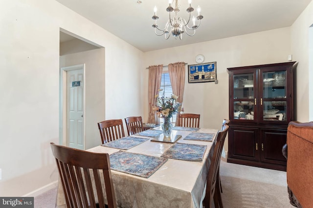 dining area with light carpet and an inviting chandelier