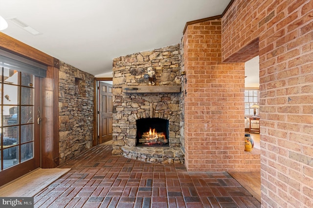 unfurnished living room featuring a stone fireplace and vaulted ceiling