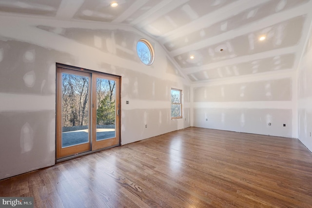 spare room with lofted ceiling with beams and wood-type flooring