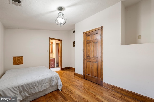 bedroom featuring light hardwood / wood-style floors and vaulted ceiling