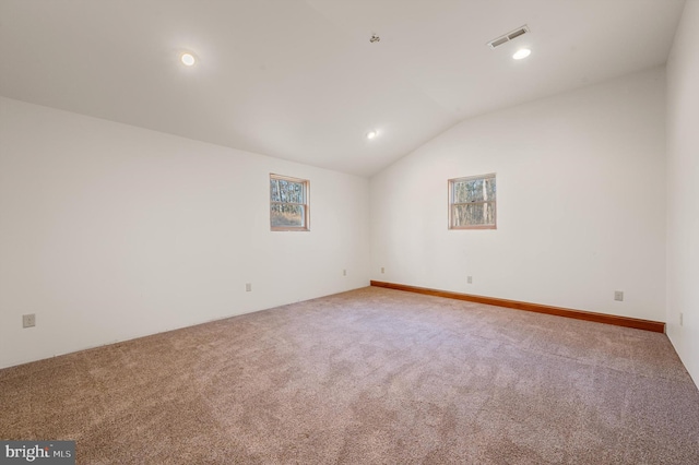 spare room featuring carpet and vaulted ceiling