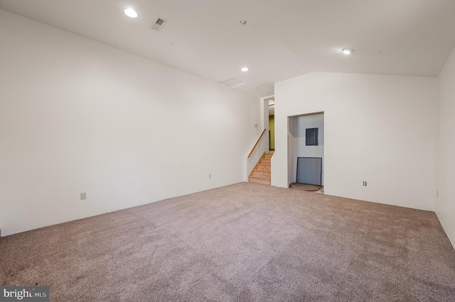 empty room featuring carpet, lofted ceiling, and electric panel