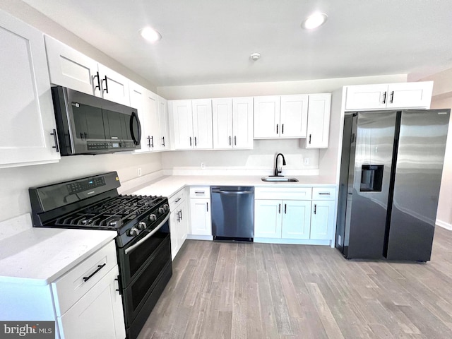 kitchen with white cabinetry, sink, and black appliances