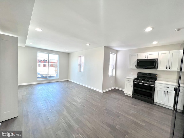 kitchen featuring hardwood / wood-style floors, white cabinetry, and black appliances