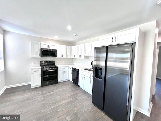 kitchen with white cabinets, light wood-type flooring, sink, and appliances with stainless steel finishes