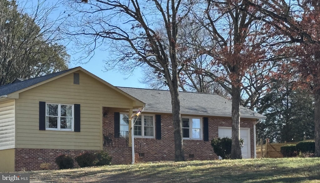 view of front of house featuring a shingled roof, crawl space, an attached garage, a front lawn, and brick siding