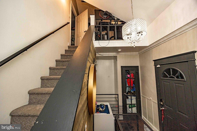 staircase with an inviting chandelier and ornamental molding