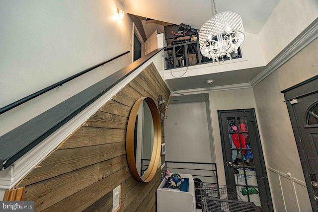 staircase with ornamental molding and a notable chandelier