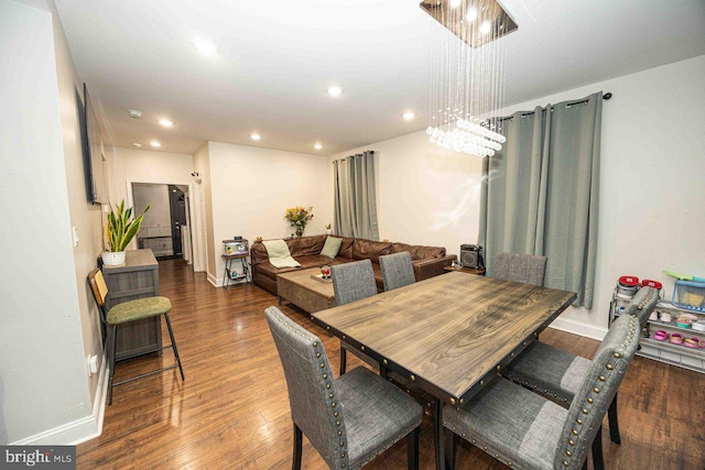 dining room featuring dark hardwood / wood-style floors and an inviting chandelier