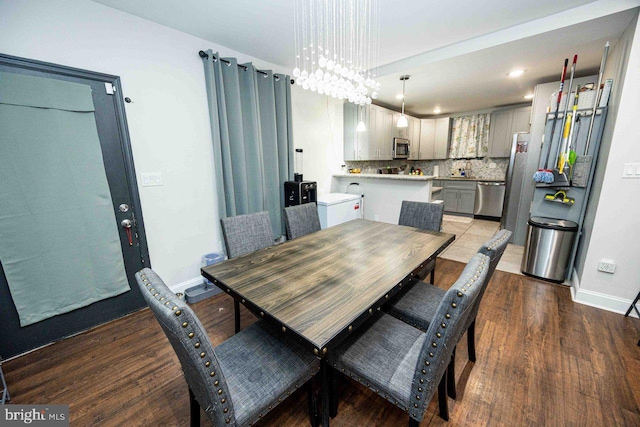 dining space with dark hardwood / wood-style flooring and a chandelier