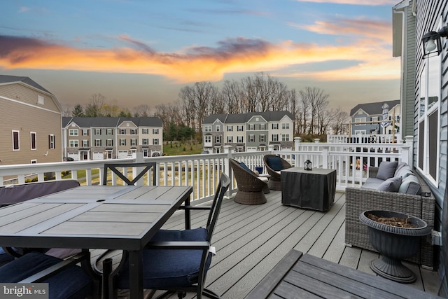 deck at dusk with an outdoor living space with a fire pit