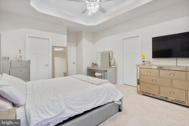 carpeted bedroom featuring ceiling fan and a raised ceiling