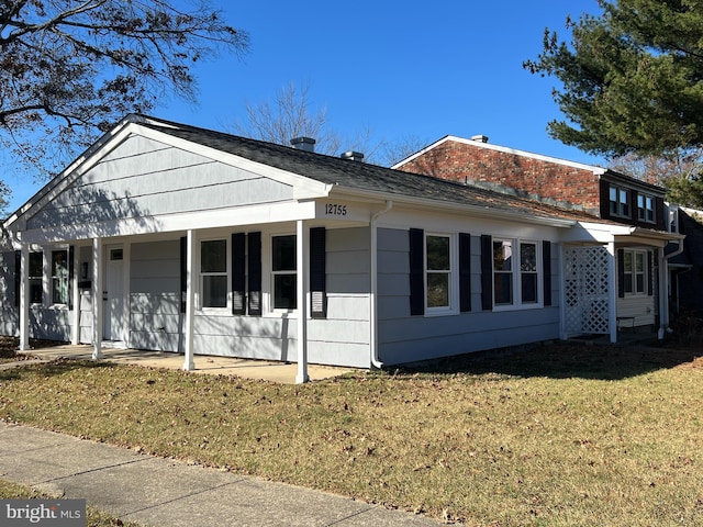 view of side of home with a lawn and covered porch