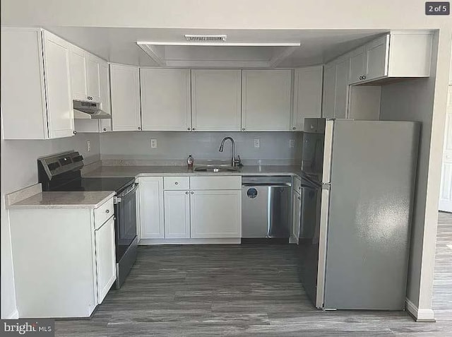 kitchen featuring appliances with stainless steel finishes, dark hardwood / wood-style floors, white cabinetry, and sink