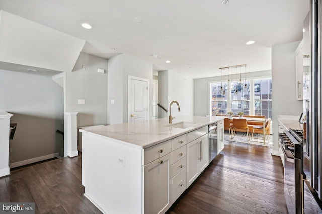 kitchen featuring sink, hanging light fixtures, a center island with sink, white cabinets, and appliances with stainless steel finishes