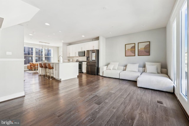 living room with dark hardwood / wood-style floors and sink