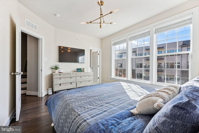 bedroom featuring a chandelier and dark hardwood / wood-style floors