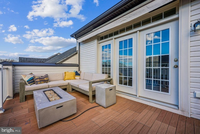 wooden terrace with an outdoor living space with a fire pit