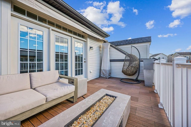 deck featuring an outdoor living space with a fire pit