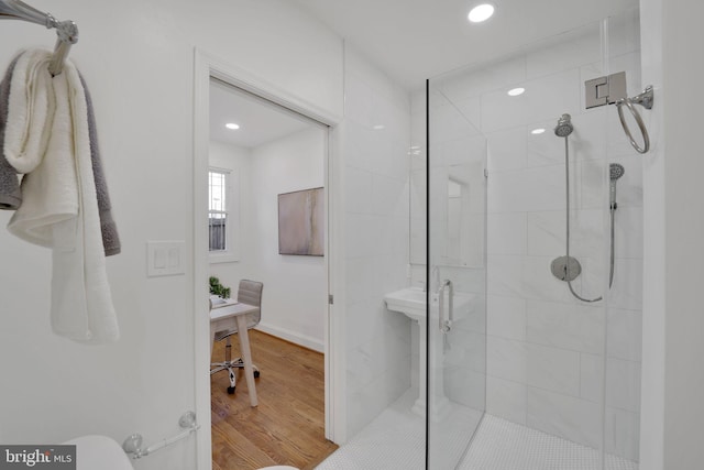 bathroom with hardwood / wood-style floors and a shower with door