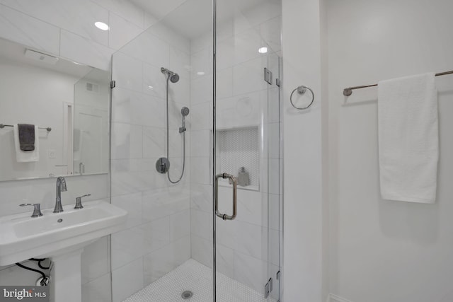 bathroom with sink and a shower with shower door