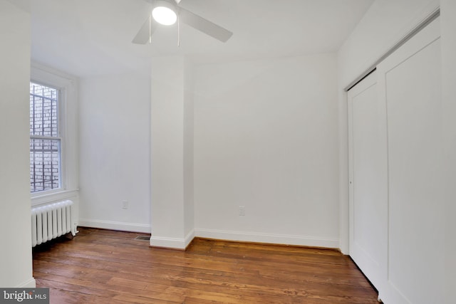 unfurnished bedroom featuring a closet, dark hardwood / wood-style flooring, ceiling fan, and radiator heating unit