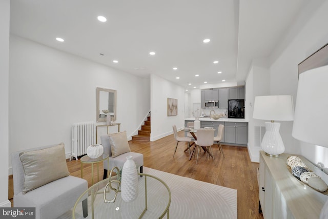 living room with radiator heating unit and light hardwood / wood-style floors