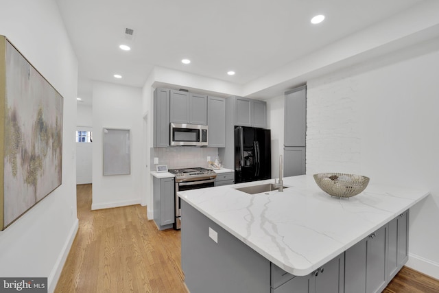 kitchen featuring kitchen peninsula, gray cabinetry, sink, and stainless steel appliances