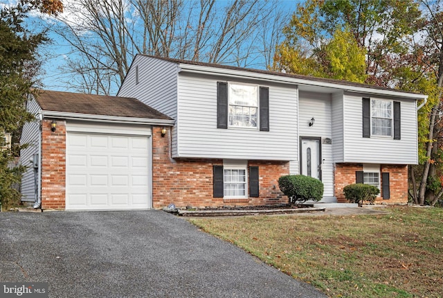 bi-level home featuring a garage and a front lawn